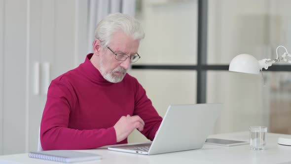 Old Man Working on Laptop in Office