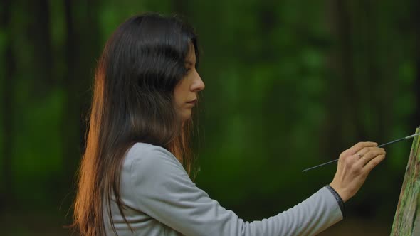 Beautiful Girl Drawing a Landscape on the Nature in the Forest