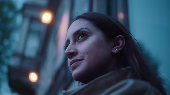 Close up of young woman leaning towards a house wall