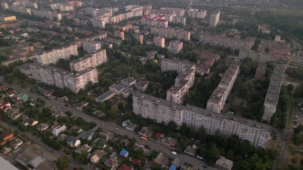 Drone Flying Over Apartment Buildings and Street in Small European City at Summer Evening