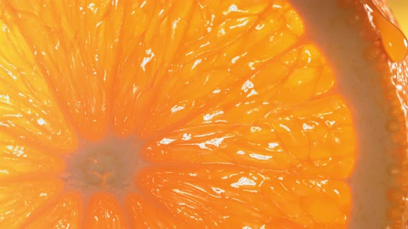 Drop of Water Flows Down the Surface of a Ripe Juicy Orange Slice