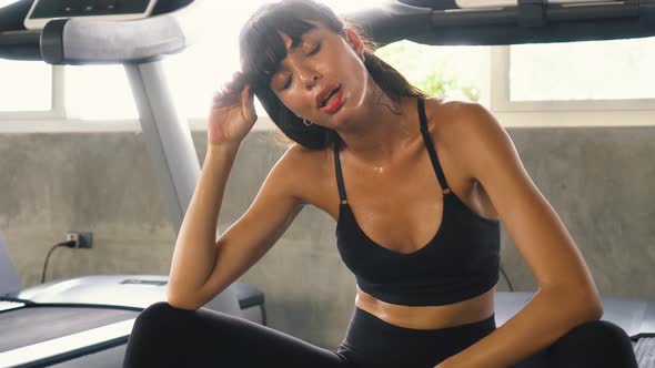 Tired Caucasian Woman Sweating While Resting Over Treadmill After Training at the Gym