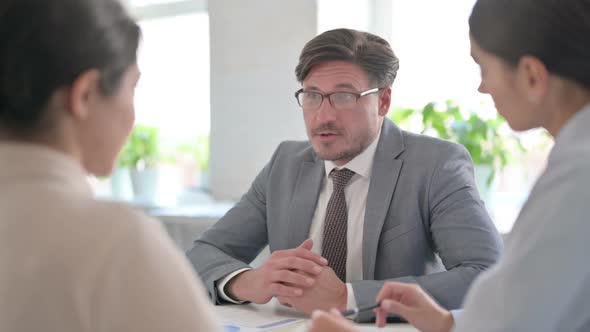 Serious Male and Female Business People having Conversation in office