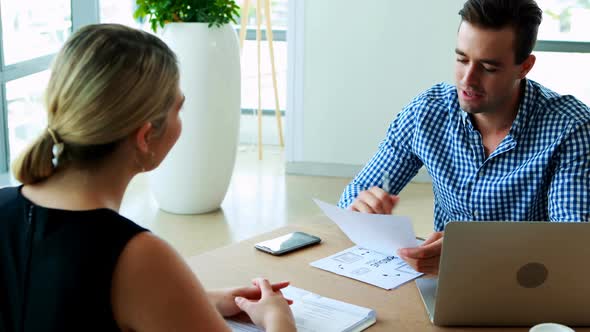 Executives interacting with each other at desk