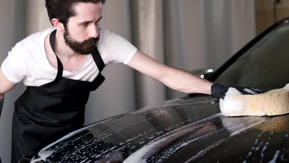 Man Washing His Car in a Garage