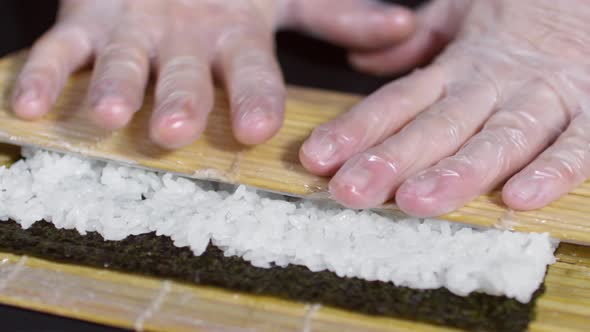 Cook Preparing Sushi with Bamboo Mat