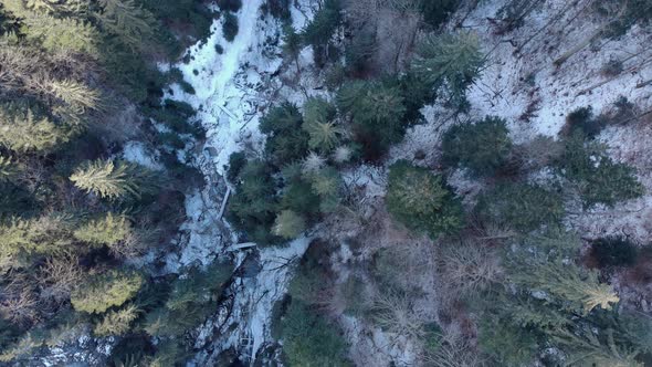 Above View Of High Forest Mountains With Frozen Stream In Winter