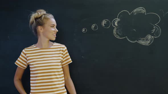 Portrait of woman in front of chalkboard