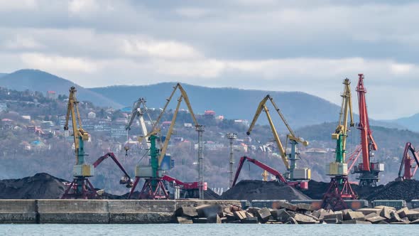 The cranes are loading bulk materials and coal in the seaport.