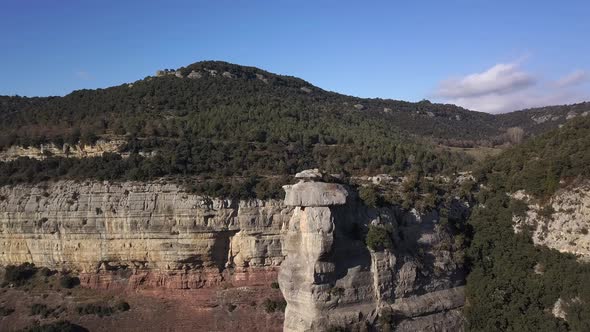 Aerial view of vertical cliffs covered by green vegetation, arc shot