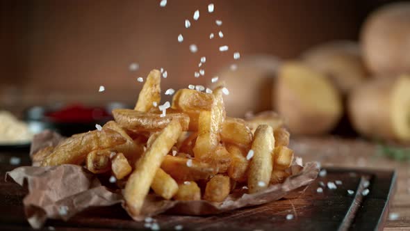 Super Slow Motion Shot of Adding Salt on Fresh French Fries at 1000Fps