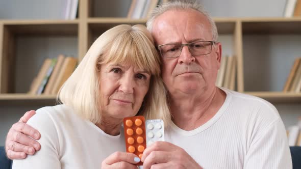 Sad Grandfather and Grandmother Hold a Plate with Pills in Their Hands