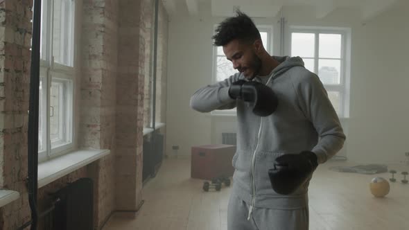 Afro Sportsman Putting On Boxing Gloves