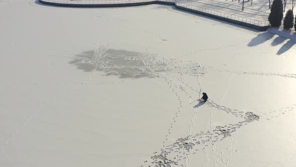 Aerial Drone Shot Fisherman Is Fishing Alone on Frozen River