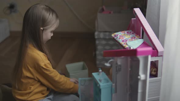 Little Girl Playing With Dollhouse