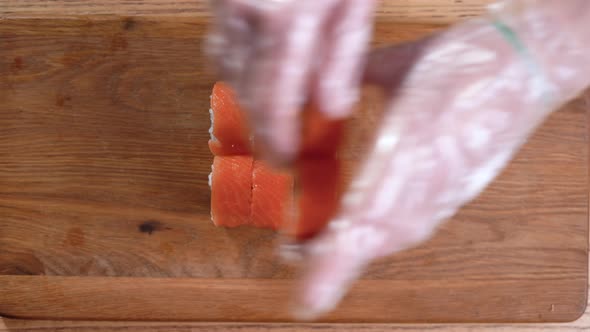 Cooking Sushi at Home Closeup of Male Hands Placing Rolls on a Cutting Board
