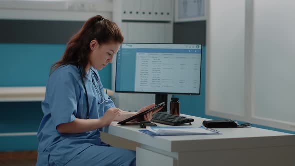 Medical Assistant Working with Computer and Digital Tablet