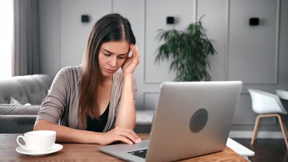 Upset Young Female Feeling Tired Massaging Temples Sitting at Desk