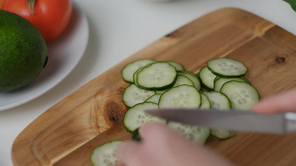 Close-up of  Female hands cut a cucumber Cooking Salad.