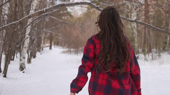 Female in Checkered Shirt Walking in Snowy Park