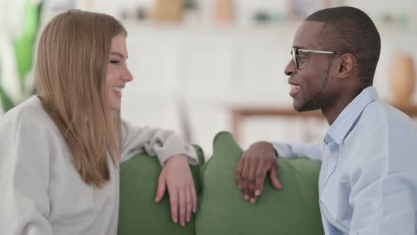 Attractive Mixed Race Couple Having Conversation While Sitting on Sofa