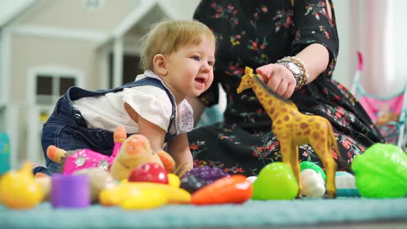 Cute Little Baby Playing with Toy Giraffe