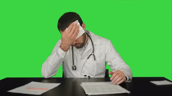 Tired Overworked Doctor in Hospital on a Green Screen, Chroma Key