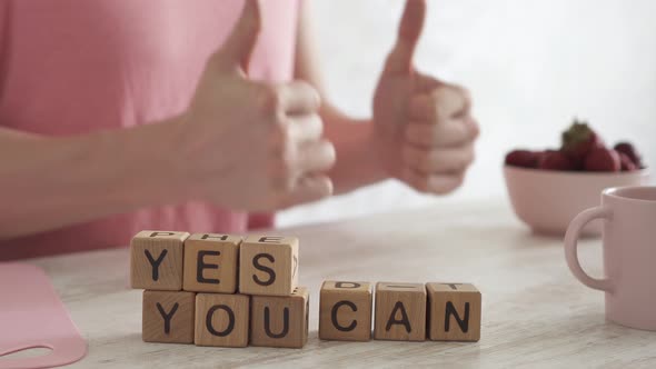 Phrase That Motivates You To Win, Yes You Can, Made Up Of Cubes. Male Hands Show A Gesture All Right