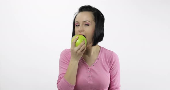 Young Woman Eating Apple and Says Yum. Girl Takes First Bite and Say Wanna Bite