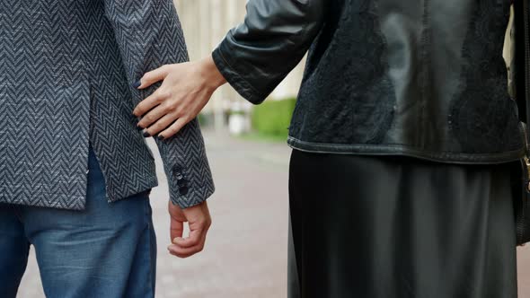 Man and Woman are Walking in City Holding Hands Rear Closeup View Romantic Walk in Downtown