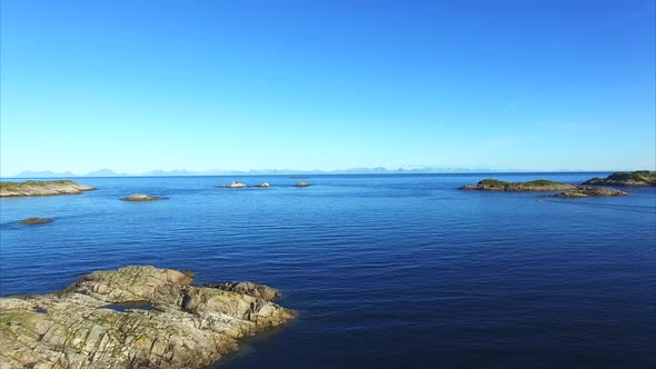 Flight above small rocky islands in the sea