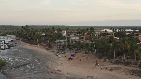 Crane flight toward beach buggy's by Brazil hotel resort on low tide beach