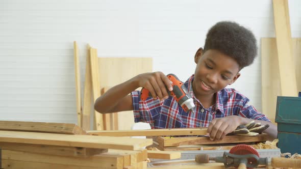 little child with a drill in hands help dad assembling furniture shelf with power screwdriver tool