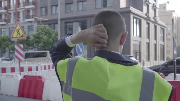 Back View of Little Boy Removing a Helmet, Scratches His Head and Puts on a Helmet