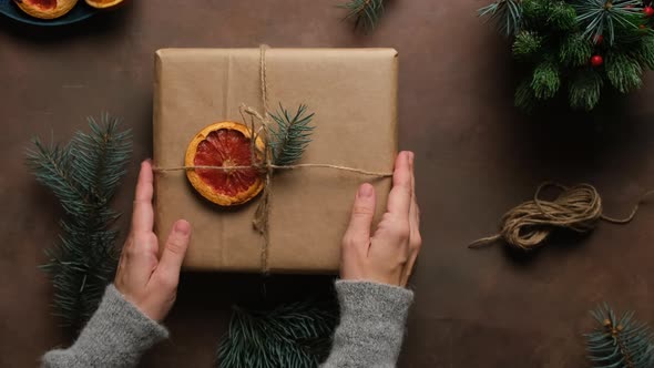Hands Decorates Christmas Gift Box with Dried Grapefruit