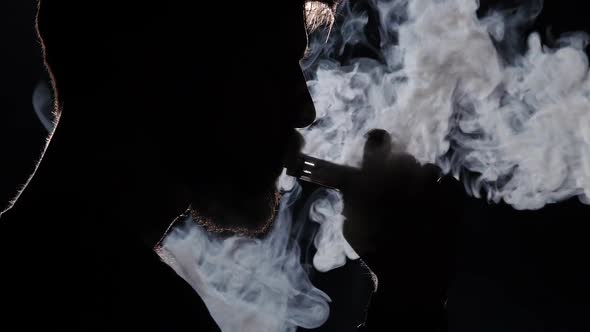 Electronic Cigarette. Exquisitely Beautiful Smoke. Black. Silhouette. Close Up