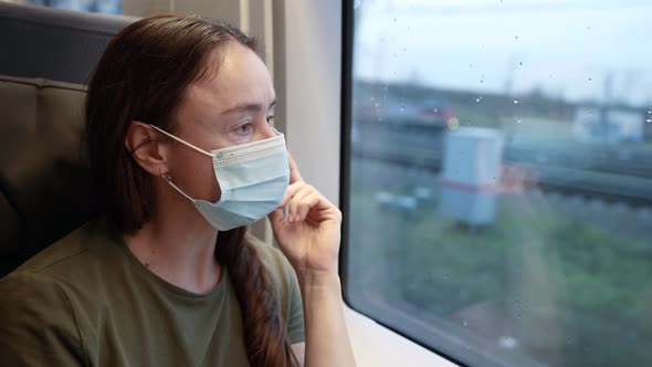 Portrait of an Adult Woman Traveling By Train in the Coronavirus Pandemic Wearing a Protective
