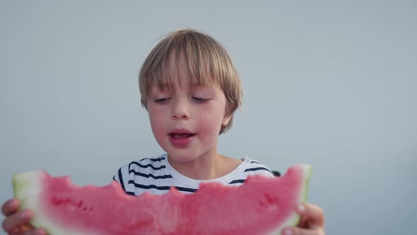 Caucasian Boy Eats Watermelon at Home