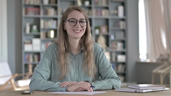 Cheerful Woman Smiling and Looking at Camera While Sitting