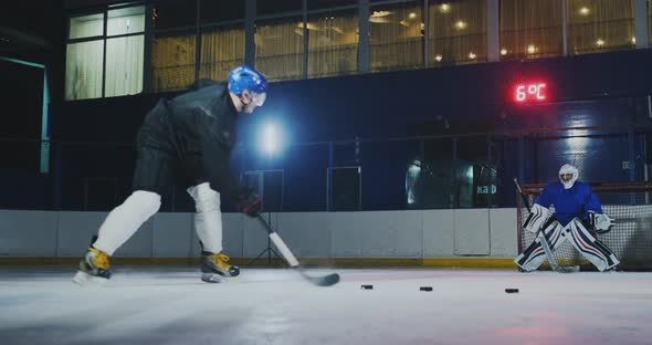 Professional Hockey Player and Goalkeeper Train Punching Puck on Goal