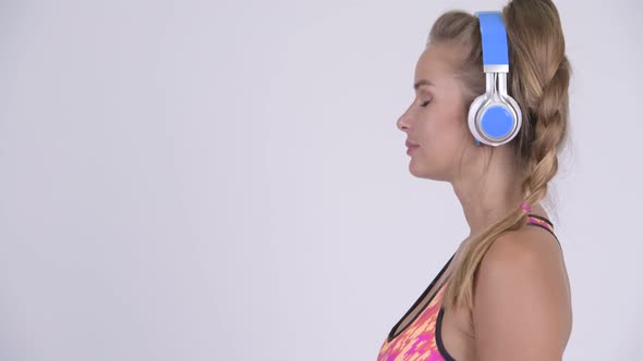Profile View of Young Beautiful Blonde Woman Listening To Music