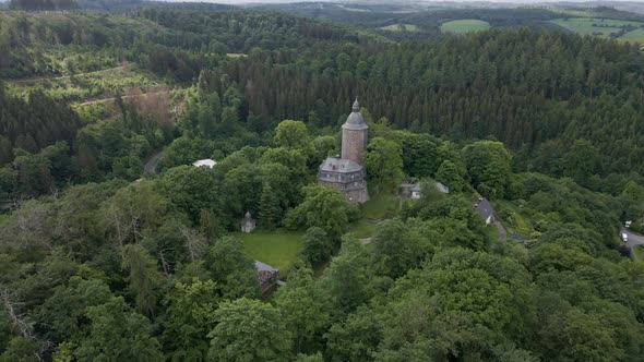 down tilting drone shot of Wildenburg Castle in the southeast of the village of Friesenhagen , in th