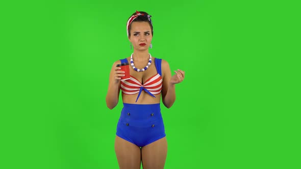 Beautiful Girl in Swimsuit Drinking Unpalatable Coffee and Is Disgusted. Green Screen