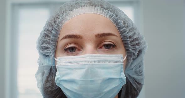 The Doctor's Face of in a Medical Mask and Cap Closeup