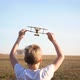 The Child Runs Across the Field Holding a Plane Simulates Flight - VideoHive Item for Sale