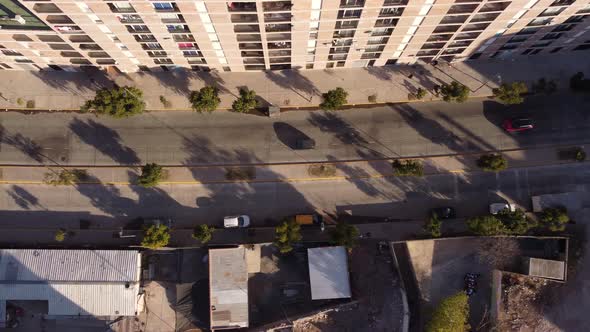 Aerial overhead tracking shot of cars driving on road at Chacarita Area in Buenos Aires during sunse