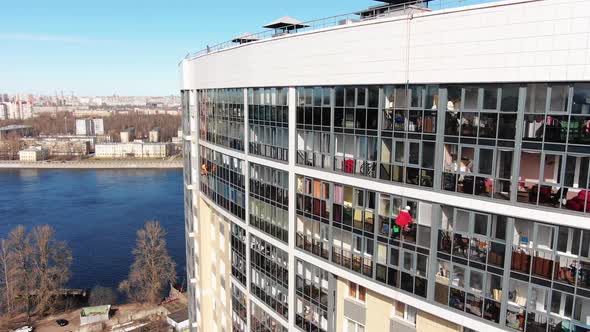 Industrial Climber Cleans Window of Hotel Near River