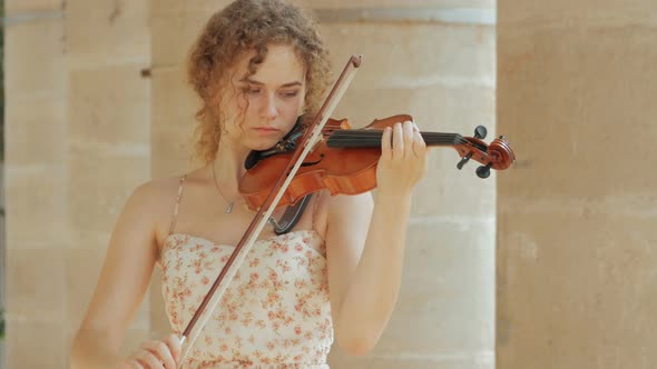 young curly blond woman the violinist: Musician playing violin