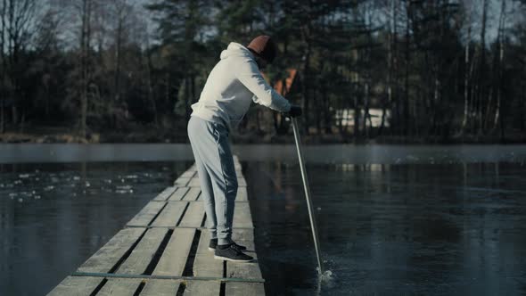 Caucasian adult man preparing for swimming in frozen lake. Shot with RED helium camera in 8K.