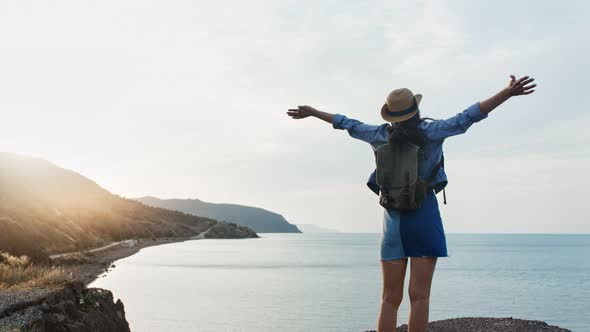 Happy Travel Hipster Female Having Positive Emotion Raising Hand Looking on Seascape at Sunset